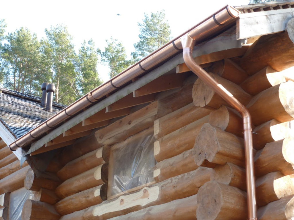 Бревенчатый дом среди сосен с медными водостоками Zambelli