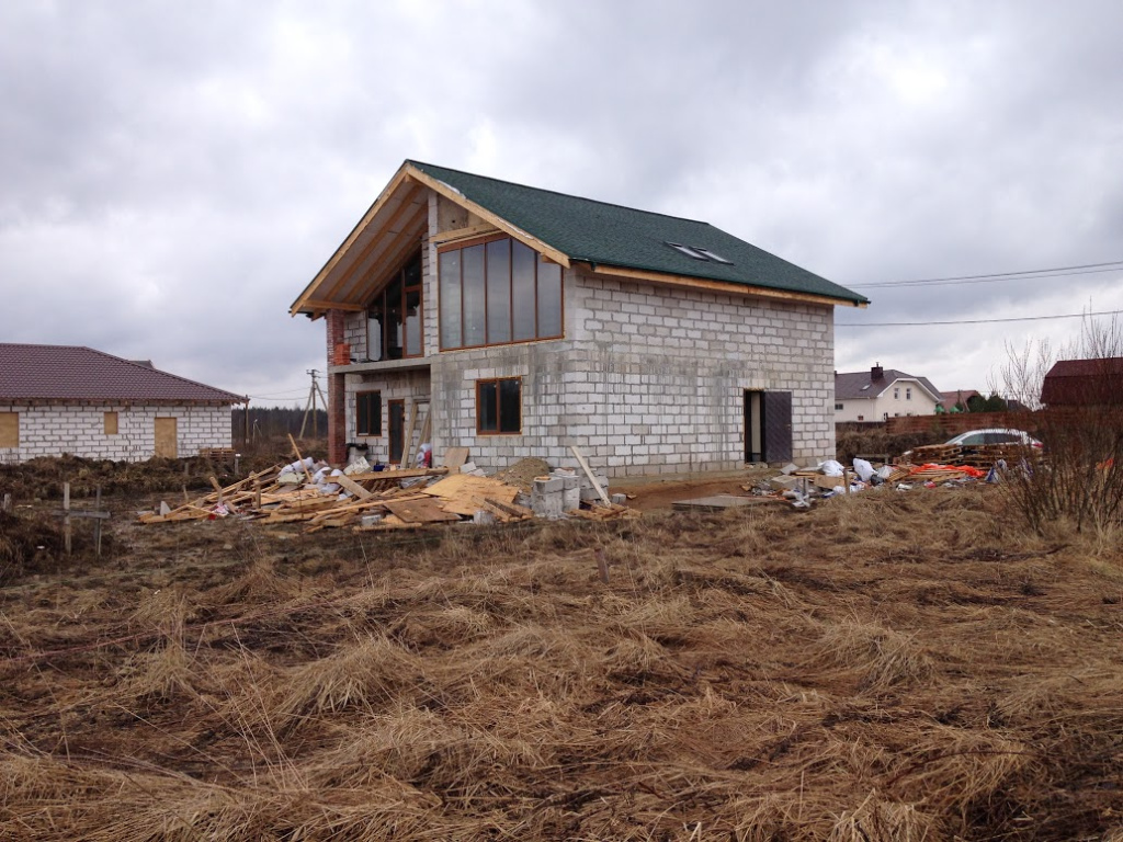 Загородный дом серые кирпичные стены под зеленой черепицей